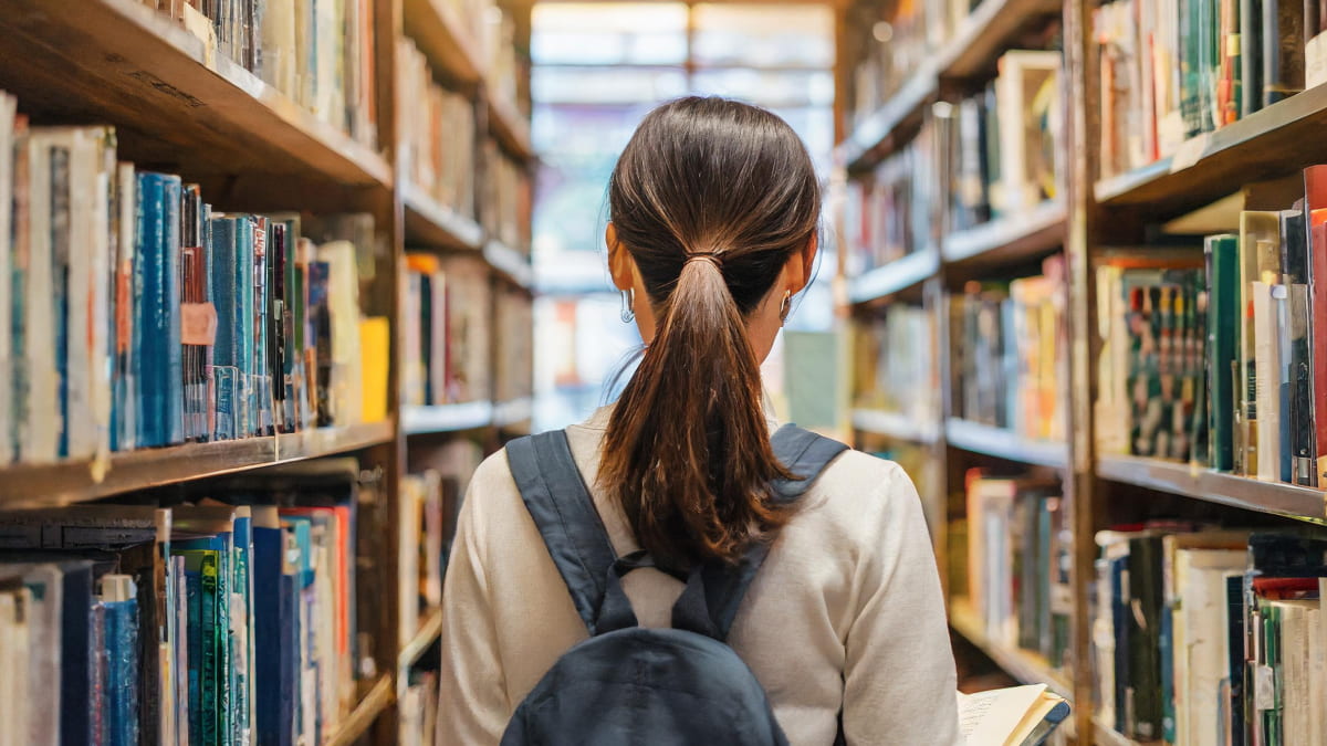 図書館で本を探す女性